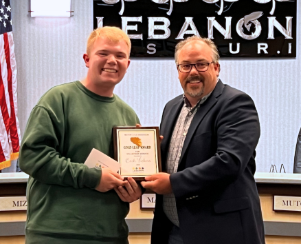 Cash Vickers receives a gold leaf award from mayor jared carr