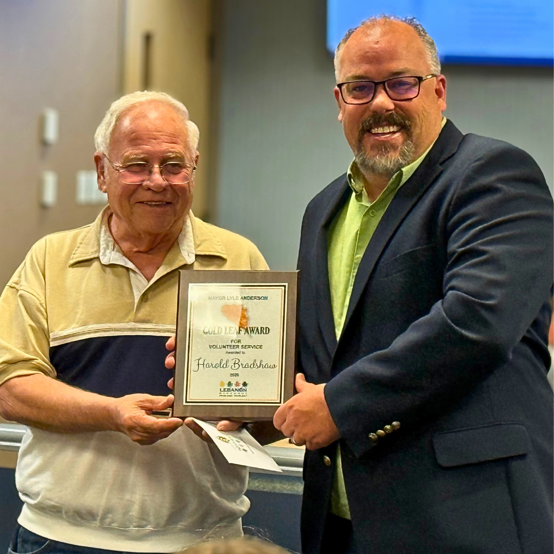 Harold Bradshaw stands with Mayor Jared Carr as he receives the 2025 Mayor Lyle Anderson Gold Leaf A